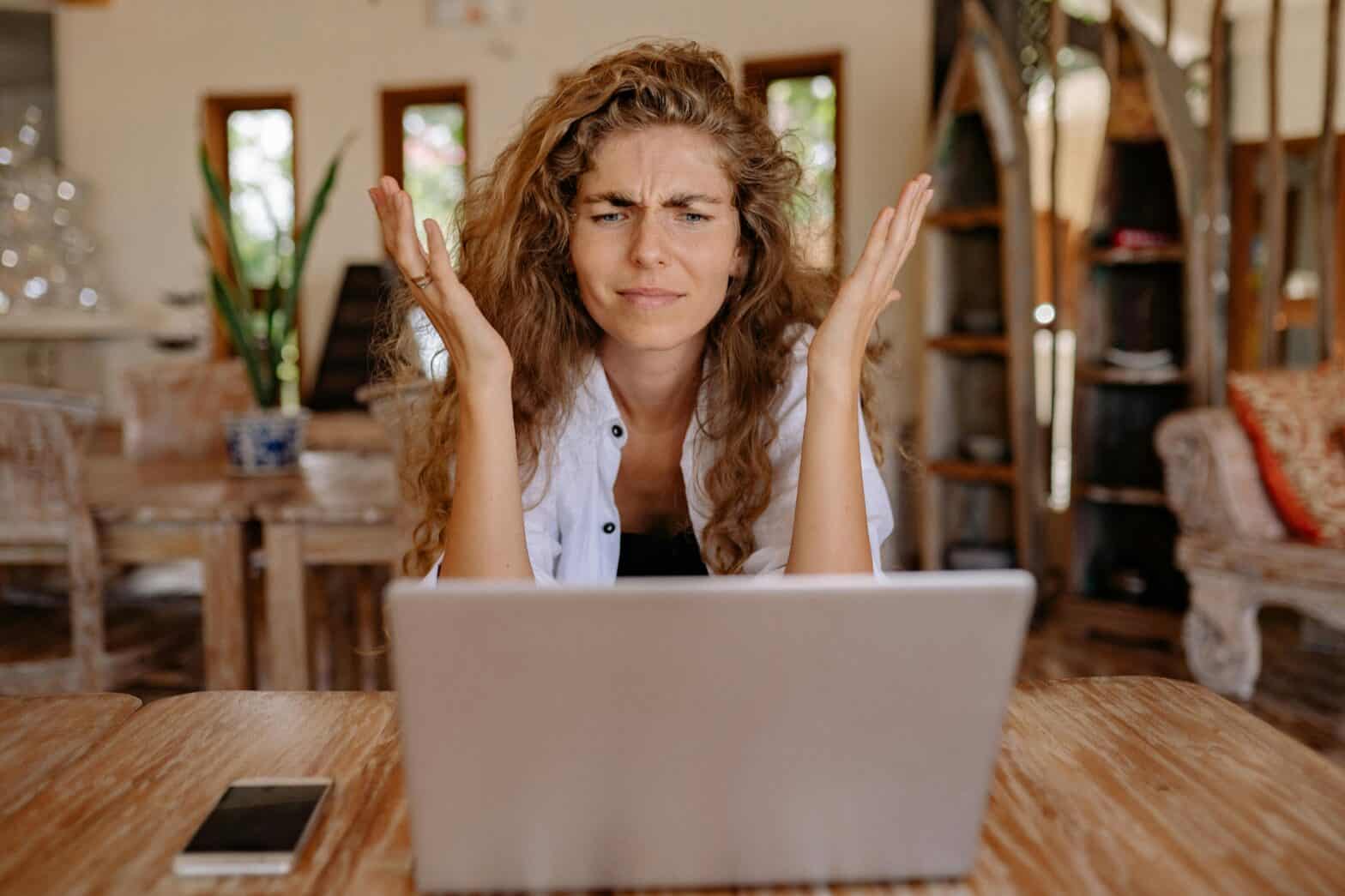 Frustrated woman looking at her laptop, representing HOA community disputes.