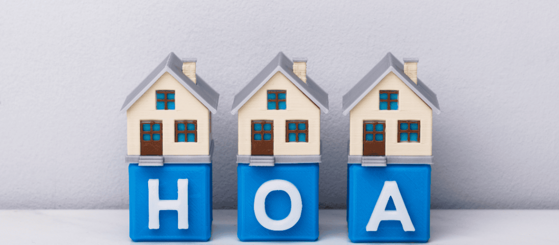 HOA management concepts with house models and blocks spelling HOA.