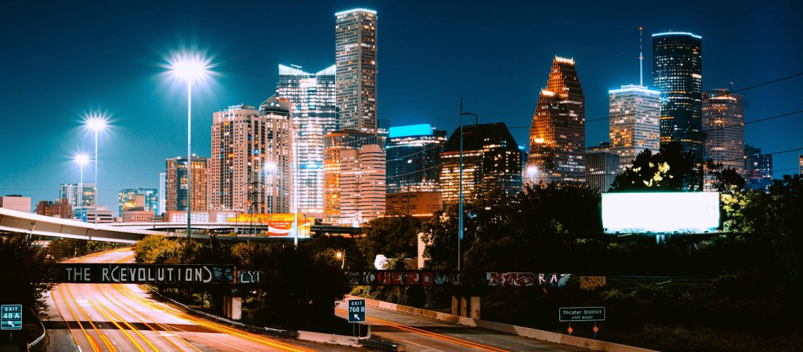 Houston skyline at night with bright city lights and tall buildings.