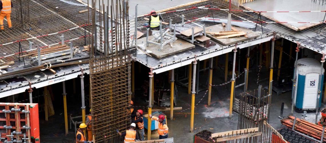 KRJ Cares construction site with workers and reinforced concrete foundation.