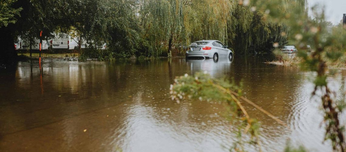 Flooded street with submerged cars due to water rise and lack of response.