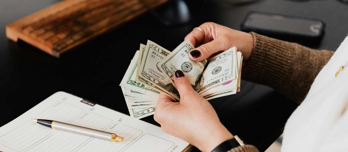 Woman counting cash for neighborhood financial planning and development.
