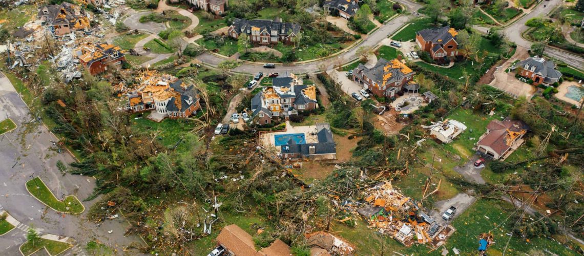 Aerial view of storm destruction with fallen trees and damaged homes after hurricane season begins.