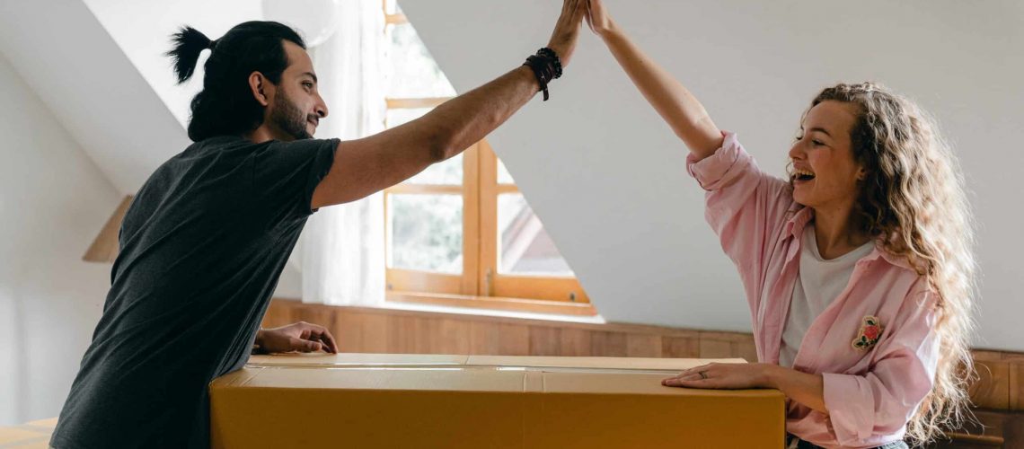 High-five between new homeowners celebrating their move-in success.