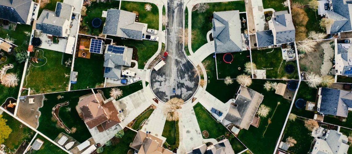Aerial view of a suburban neighborhood showing houses, lawns, and streets.