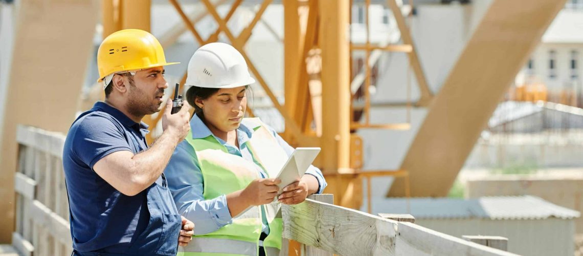 Construction workers reviewing plans on a building site.