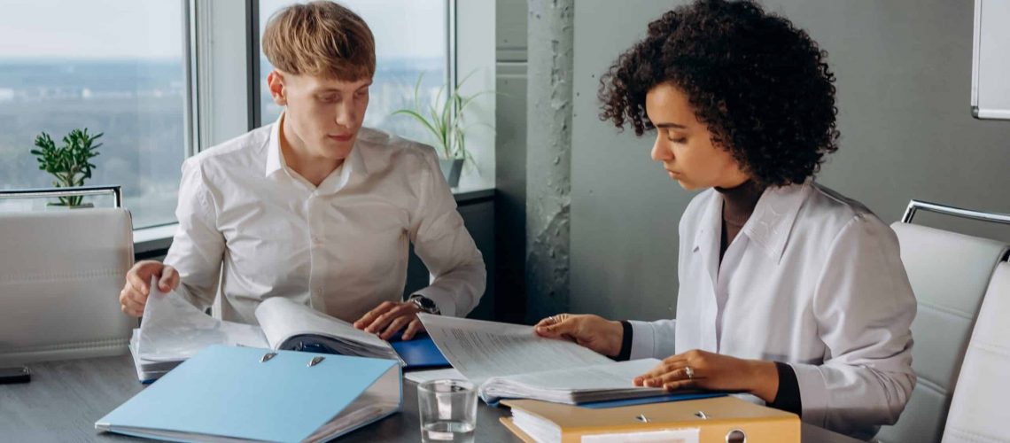 Two professionals discussing HOA management plans in a modern office setting.