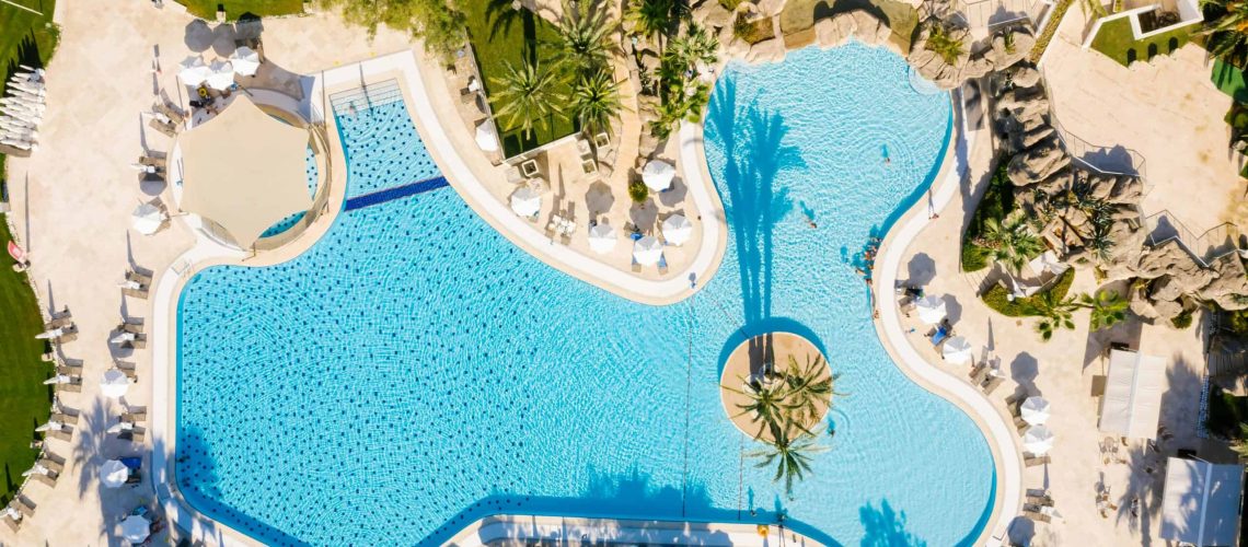 Pool area in master-planned community with amenities and tropical landscaping.