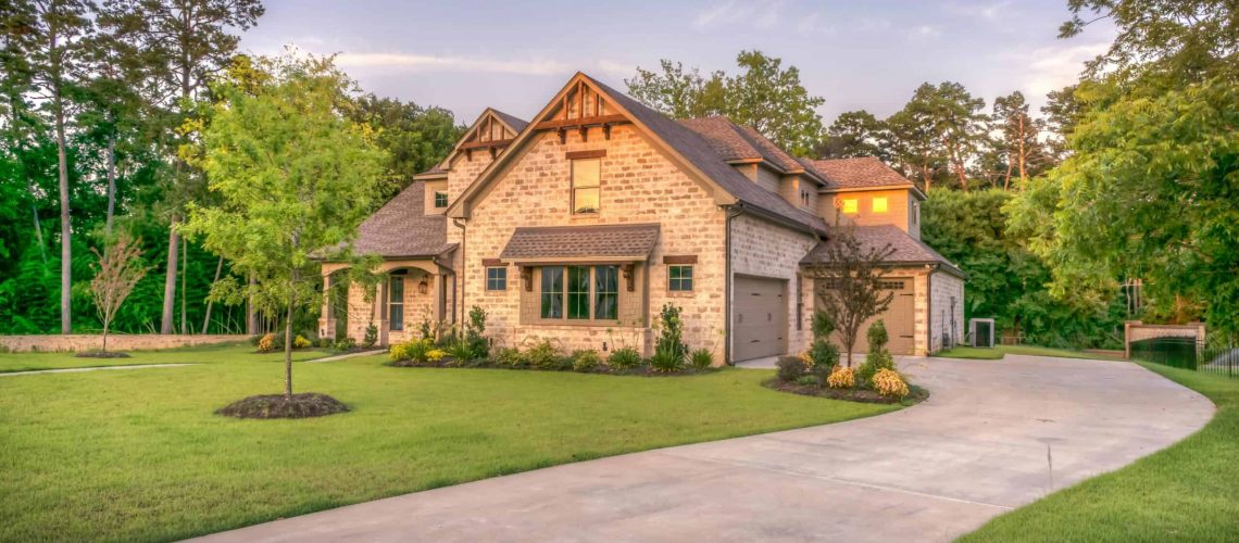 Beautiful large house in a master planned community with lush greenery and a clean driveway.