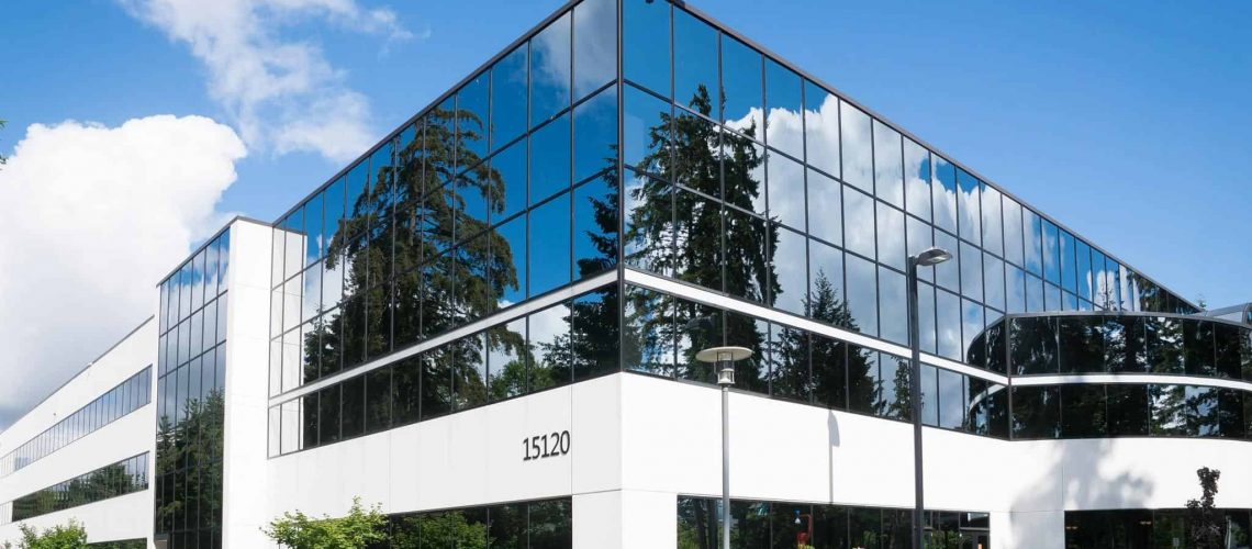 Modern commercial office building with reflective glass exterior.