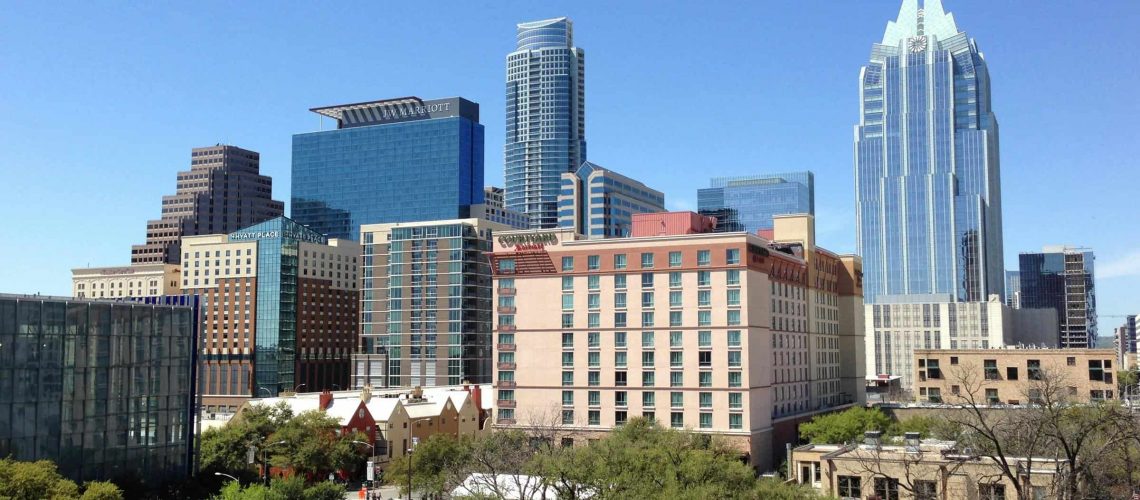 Houston city skyline featuring tall buildings and lush green spaces.