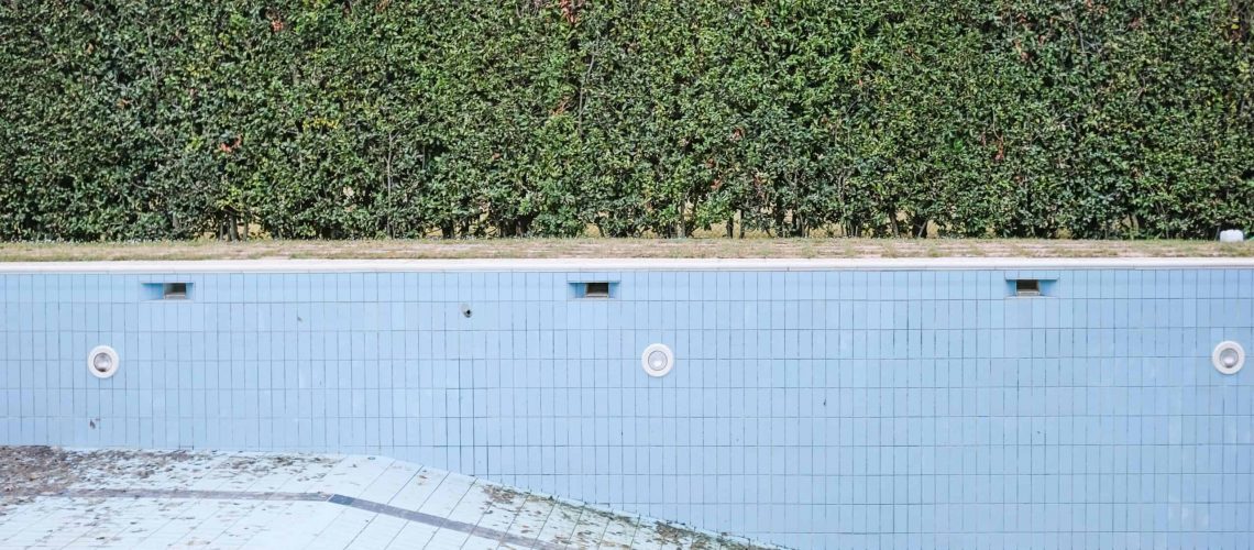 Abandoned pool in a Houston HOA community showing neglect and disrepair.