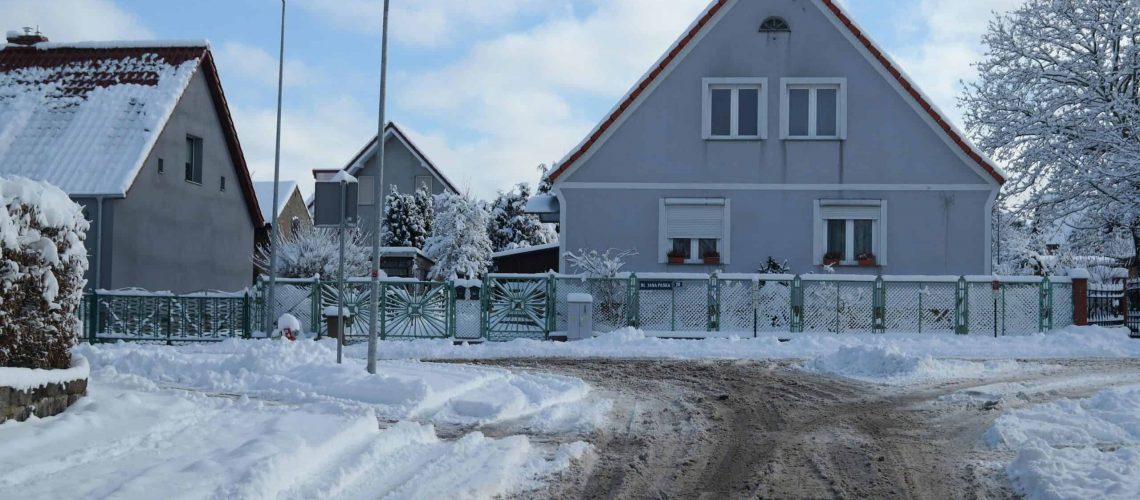 Snow-covered house in Willowbrook Estates with icy roads and winter landscape.