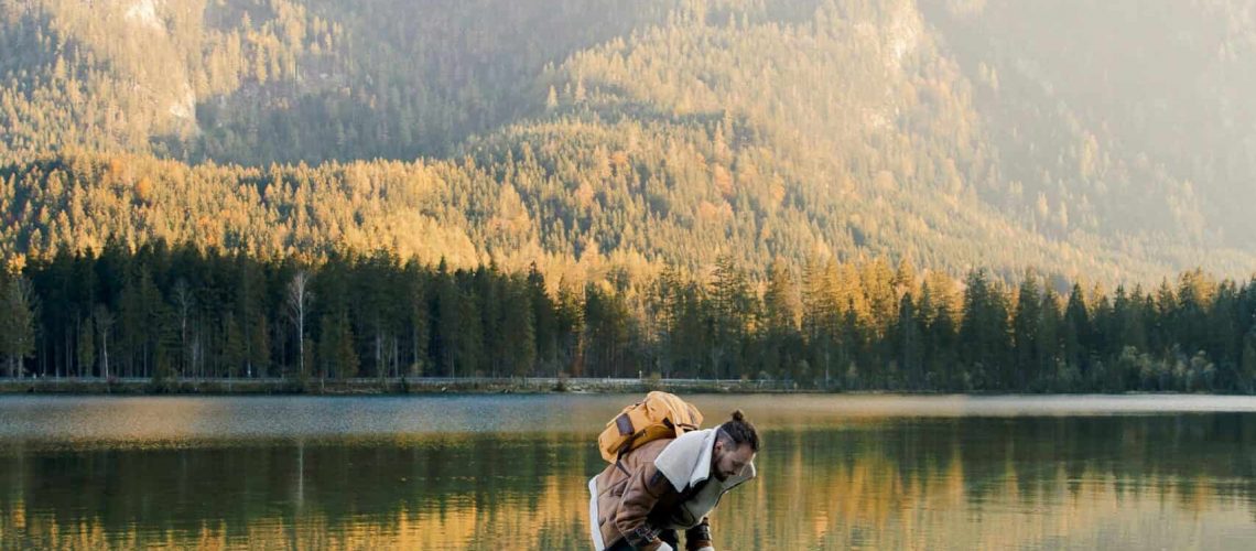 Beautiful mountain lake with boats and a father and child enjoying a day outdoors.